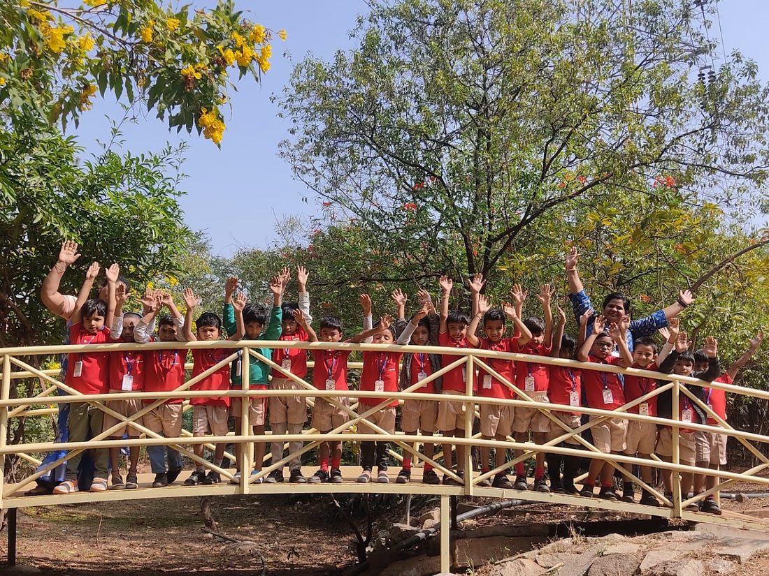 Sprout children playing on the outdoor play structure among the trees