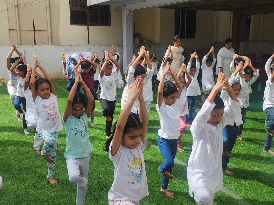 Sprout children doing yoga together on the school lawn